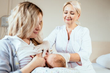 Breast feeding, a new born sucking mother breast. Positive friendly female breastfeeding consultant...