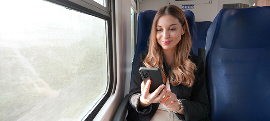 Train female passenger using mobile phone during travel commute. Panoramic banner of people...