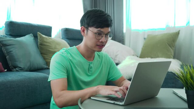 Man solving problem concept with computer technology, upset young freelancer unhappy with income or business partner, stressed Asian entrepreneur frustrated bad information investment stocks market
