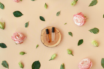Wooden podium with perfume samples on trendy pastel beige background with flower buds, leaves, petals. Abstract cosmetics composition with roses. Beauty layout. Summer, spring, aroma water concept