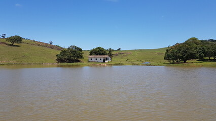 Little farmhouse house on a lake in the countryside. 