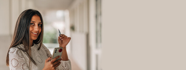young latin hispanic girl with credit card and phone. online shopping concept