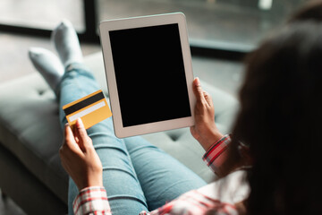 African american young female hold credit card and tablet with empty screen enjoy online shopping