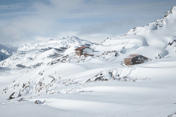 Fototapeta na wymiar Isolated small house in the middle of huge mountains covered by snow