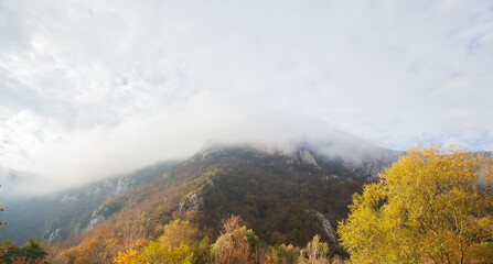 Amazing view of misty mountain peaks in autumn season in the morning. Beautiful nature, fall foggy landscape.	