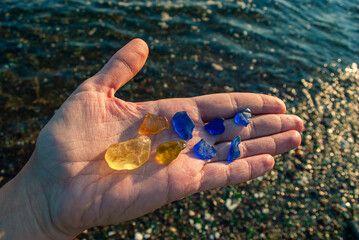 Selective focus. Sea glass. Multicolored glass in hand.