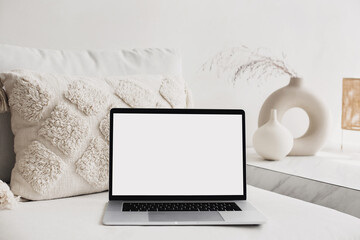 Laptop computer with empty blank mockup screen over white modern living room design. Work place,...
