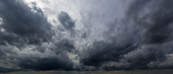 The dark sky with heavy clouds converging and a violent storm before the rain.Bad or moody weather...