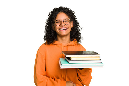 Young student woman holding a pile of books isolated laughing and having fun.