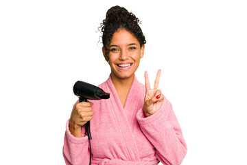 Young brazilian woman wearing a pink bathrobe holding an hairdryer isolated showing number two with fingers.