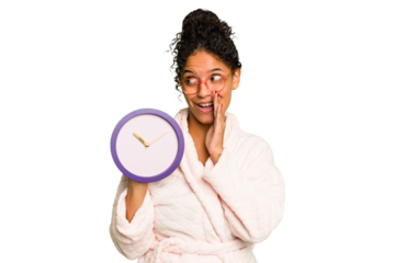 Young brazilian woman wearing a pajama holding a clock isolated is saying a secret hot braking news and looking aside