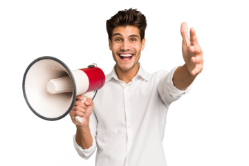 Young caucasian man holding megaphone isolated receiving a pleasant surprise, excited and raising hands.