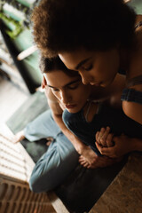 Fototapeta premium high angle view of young multiethnic artists with closed eyes holding hands in art studio.