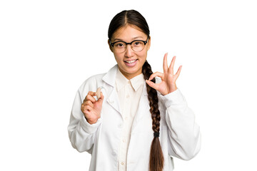 Young asian otorhinolaryngologist woman holding a hearing aid isolated cheerful and confident showing ok gesture.