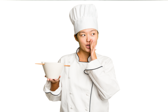 Young chef asian woman holding a bowl of ramen isolated is saying a secret hot braking news and looking aside