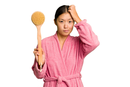 Young asian woman holding a shower brush isolated being shocked, she has remembered important meeting.