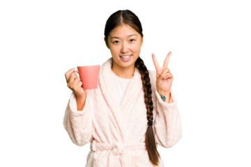 Young asian woman wearing a pajama holding a cup isolated showing number two with fingers.