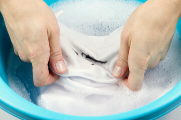Washing dirty children's clothes. Clothing with a stain lies in the pelvis