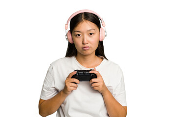 Young asian gamer woman playing with a game controller and headphones isolated