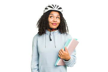 Young african american student woman wearing a helmet bike isolated dreaming of achieving goals and...