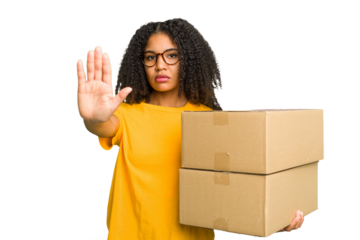 Young african american woman moving to other house while picking up a box full of things isolated standing with outstretched hand showing stop sign, preventing you.