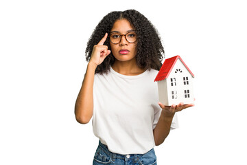 Young african american woman moving to a new home while picking up a box full of things isolated...