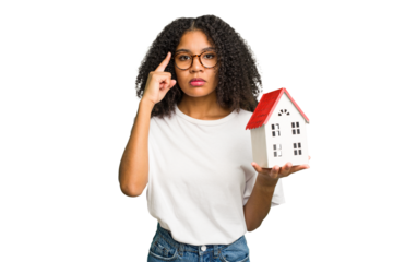 Young african american woman moving to a new home while picking up a box full of things isolated pointing temple with finger, thinking, focused on a task.