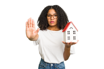 Young african american woman moving to a new home while picking up a box full of things isolated standing with outstretched hand showing stop sign, preventing you.