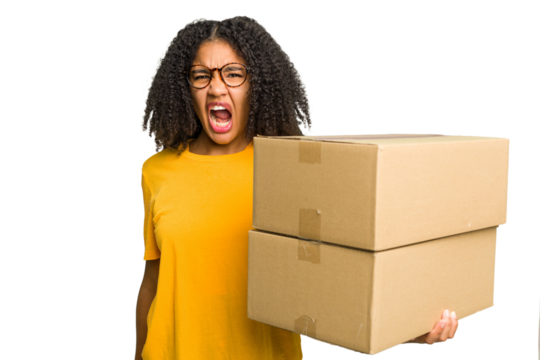 Young african american woman moving to other house while picking up a box full of things isolated screaming very angry and aggressive.