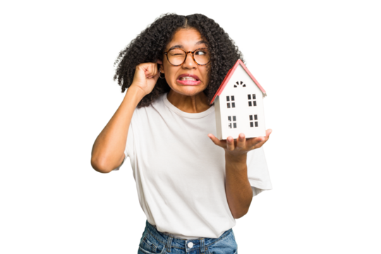 Young african american woman moving to a new home while picking up a box full of things isolated covering ears with hands. - Powered by Adobe