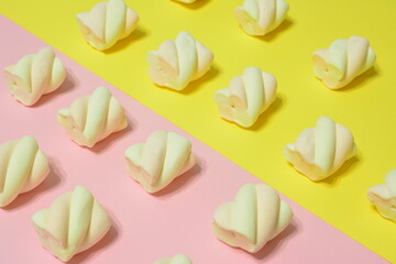 marshmallows in a row on pink and yellow background, close-up