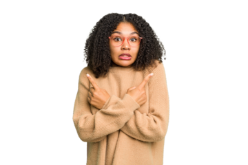Young african american woman isolated points sideways, is trying to choose between two options.