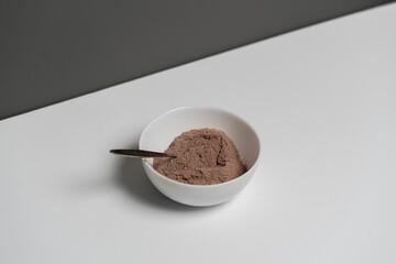 top view of brown sweet cocoa powder in white bowl