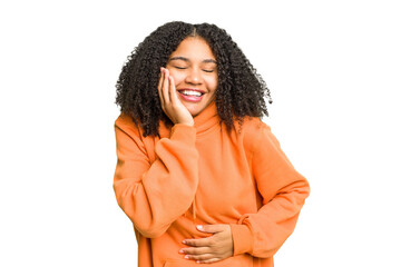 Young african american woman isolated laughs happily and has fun keeping hands on stomach.