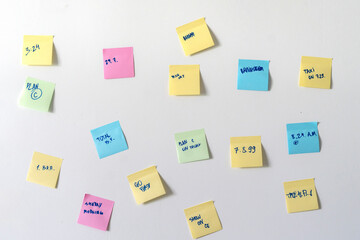 colorful paper notes attached on the wall with reminders in office