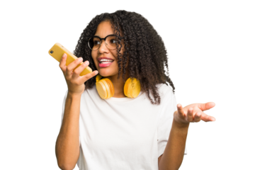 Young african american woman listening to music with headphones isolated