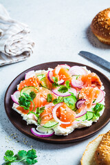 Butter board with salted salmon, cucumber, radish and cilantro on wooden plate. Party snack food, cooking trend.