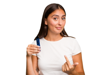 Young caucasian woman holding a electronic cigarette pointing with finger at you as if inviting come closer.