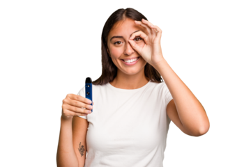 Young caucasian woman holding a electronic cigarette excited keeping ok gesture on eye.