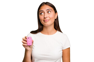 Young caucasian woman holding a car keys isolated dreaming of achieving goals and purposes