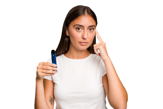 Young caucasian woman holding a electronic cigarette pointing temple with finger, thinking, focused on a task.
