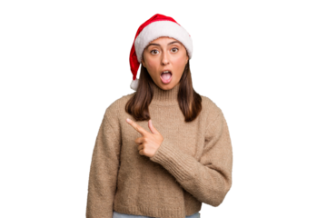 Young caucasian woman celebrating christmas wearing a santa hat isolated pointing to the side