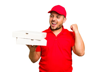 Pizza delivery caucasian man with work uniform picking up pizza boxes isolated raising fist after a...