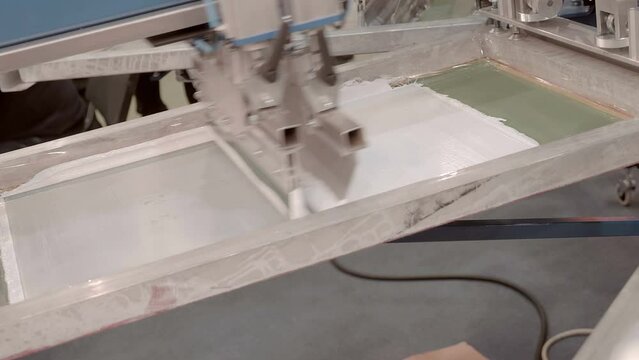Equipment for serigraphy printing, carousel type - printing on fabric by layers through a stencil, image of different colors. Closeup