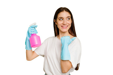 Young cleaner woman isolated points with thumb finger away, laughing and carefree.
