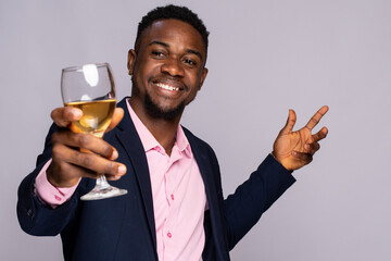 happy young black man raises a glass of wine
