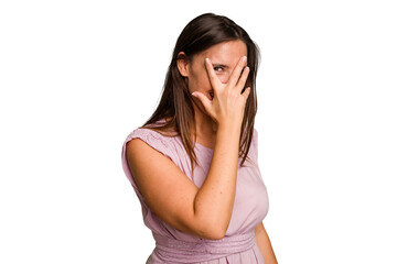 Young caucasian cute woman isolated blink at the camera through fingers, embarrassed covering face.