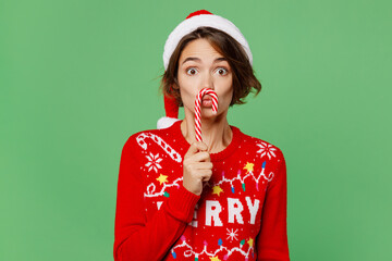 Merry fun young woman wear knitted xmas sweater Santa hat posing hold in hand candy cane pov mustache isolated on plain pastel light green background. Happy New Year 2023 celebration holiday concept. - Powered by Adobe