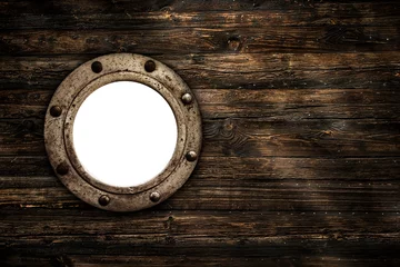 Türaufkleber Close-up of an old rusty closed empty porthole window. Old rich wood grain texture background with knots. © fotoyou