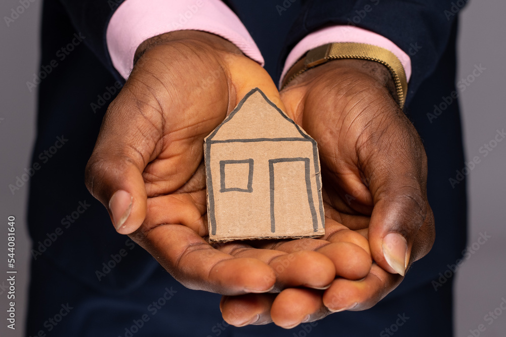 Wall mural cardboard house in the palm of a person's hand